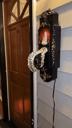 Haunted skeleton hand doorbell with glowing red eyes and motion-activated scare