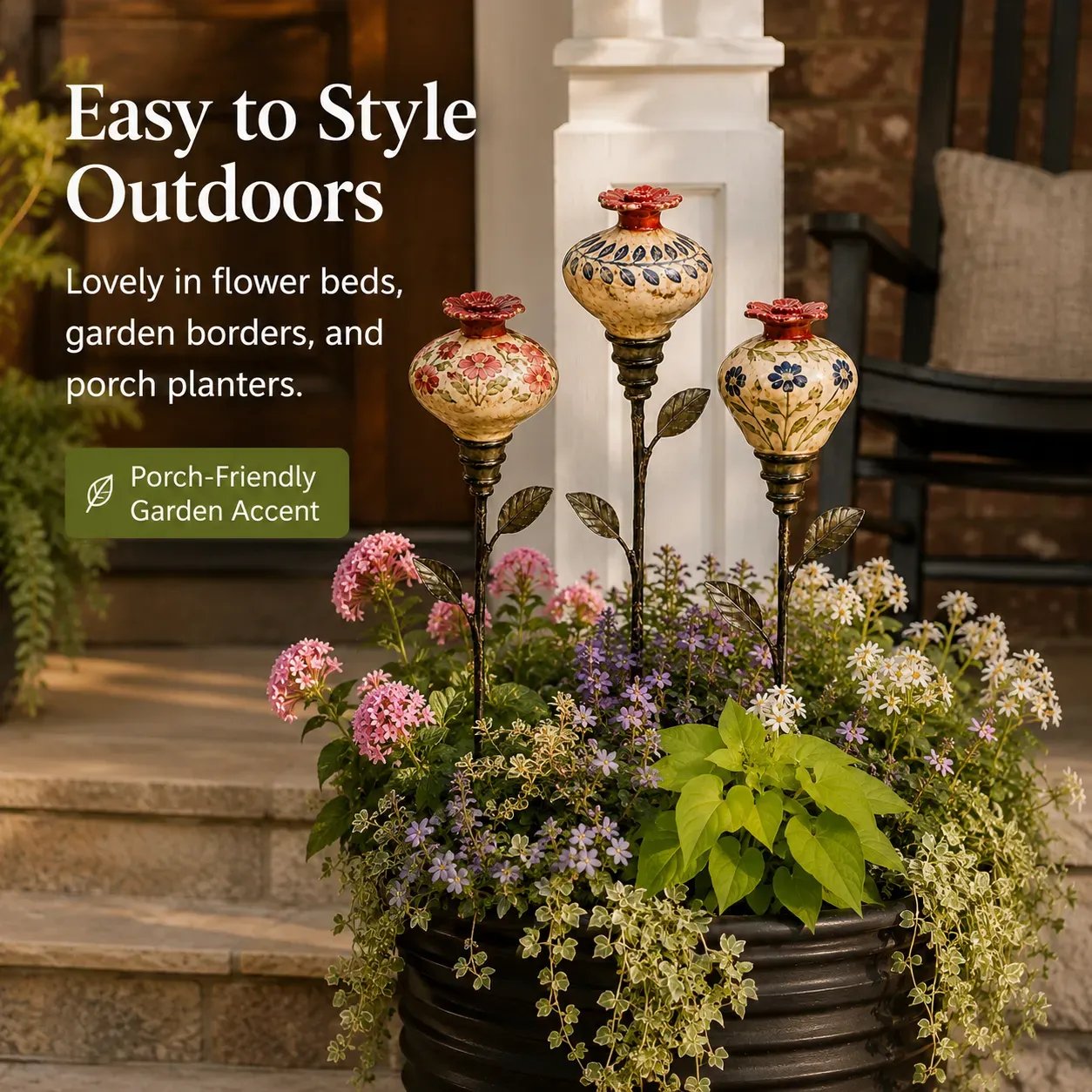 Ceramic hummingbird feeder stakes styled in a porch planter