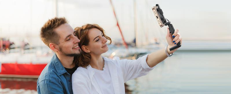 Couple taking selfie with magnetic stick Couple taking selfie with magnetic stick
